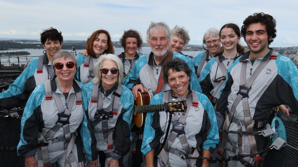 Goanna singer-songwriter Shane Howard with the Barayagal Choir atop the Sydney Harbour Bridge.
