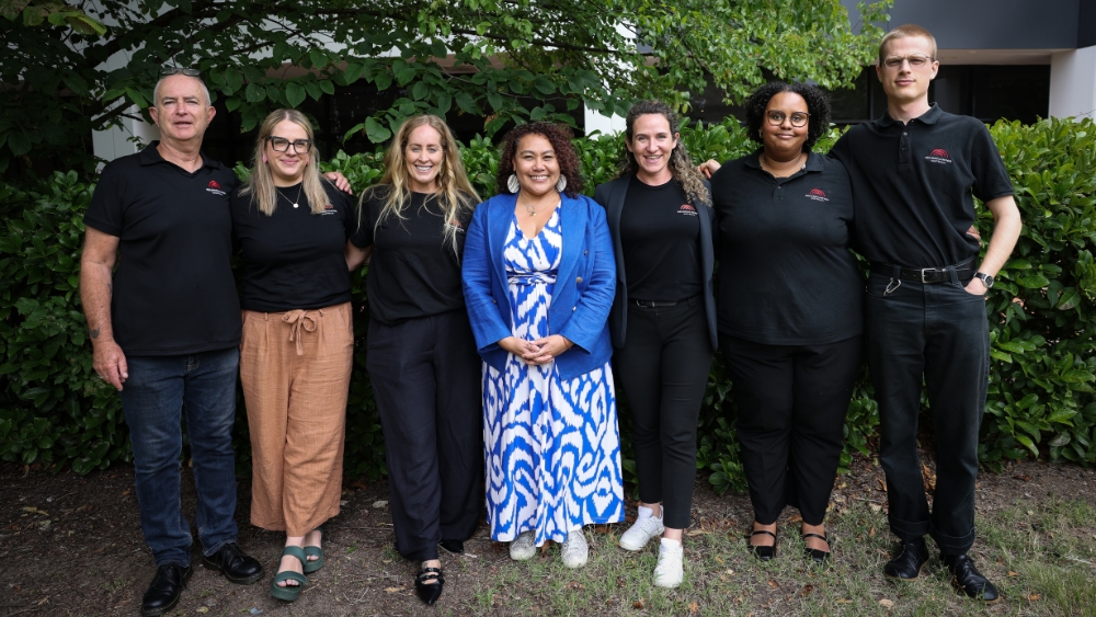 A group of Reconciliation Australia staff standing in a garden with CEO Karen Mundine